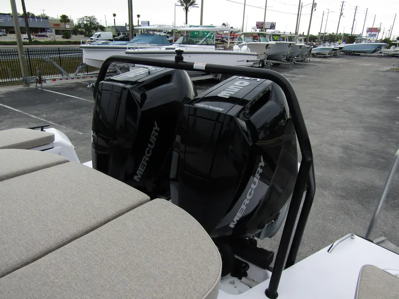 Slide: The Image of 2024 Axopar 37 Sun Top with dual Mercury outboard engines in a marina setting. - 35