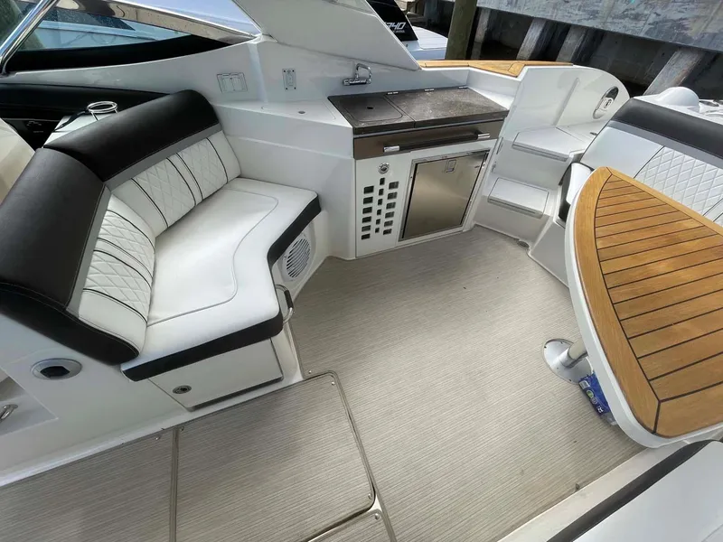 Slide: The Image of 2018 Sea Ray 350 SLX boat interior with seating and kitchenette. - 12