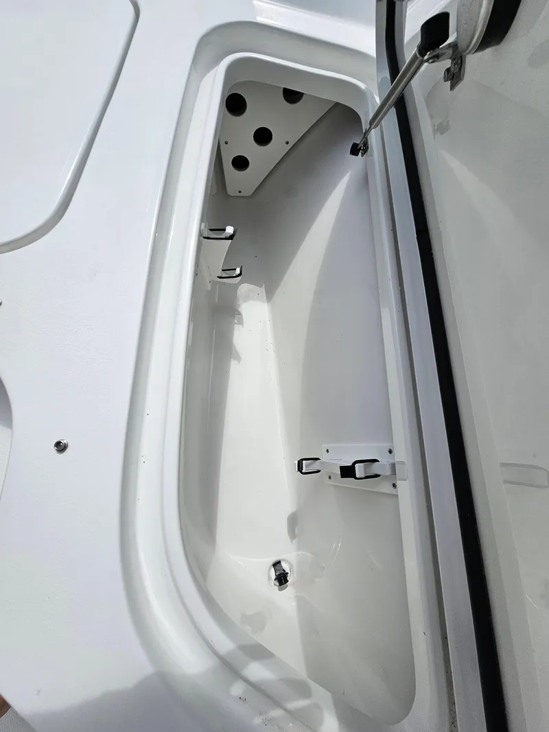Slide: The Image of 2025 Sea Hunt BX 25 FS boat storage compartment, open lid, white interior. - 21