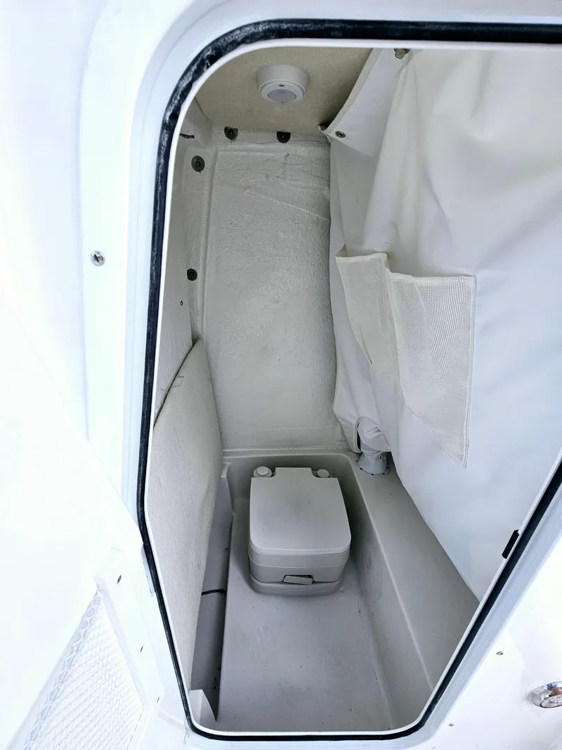 Slide: The Image of 2025 Sea Hunt BX 25 FS boat interior with compact toilet and storage. - 26
