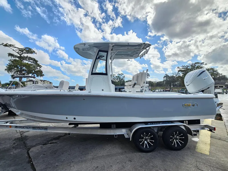 Slide: The Image of 2025 Sea Hunt BX 25 FS boat on trailer under a cloudy sky. - 5