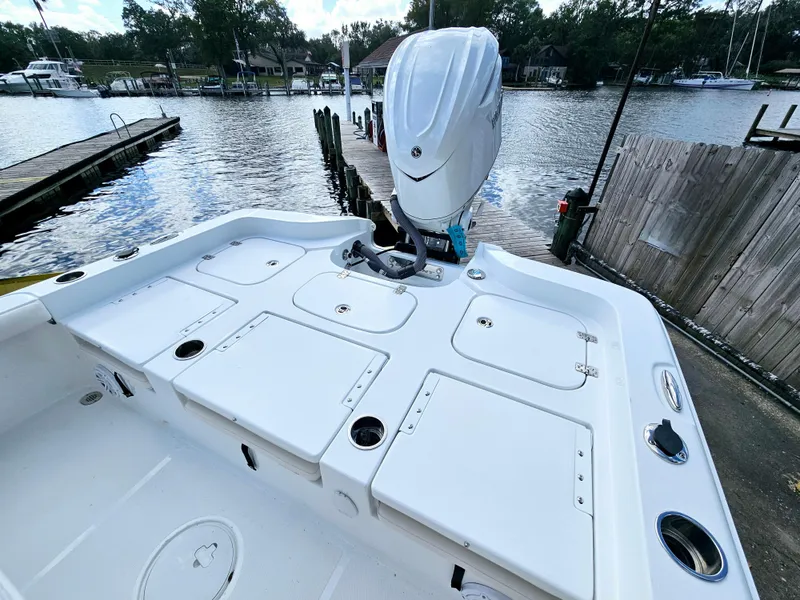 Slide: The Image of 2025 Sea Hunt BX 25 FS boat with outboard motor docked by a serene waterfront. - 7