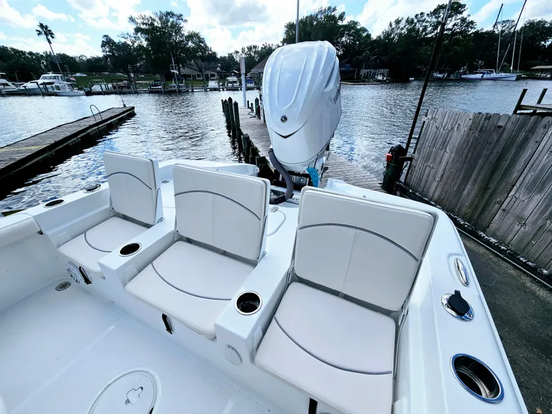 Slide: The Image of 2025 Sea Hunt BX 25 FS boat with seating, docked by a serene waterfront. - 8