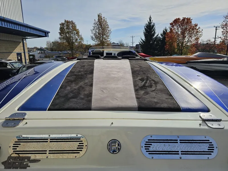 Slide: The Image of 2008 Outerlimits 46 Limited boat with blue and black accents, parked outdoors. - 45