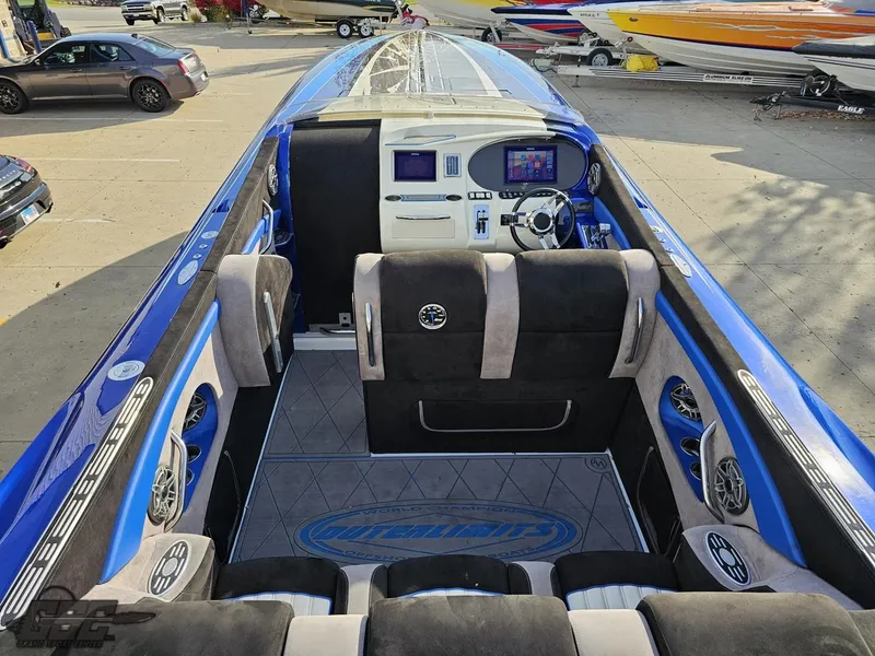 Slide: The Image of 2008 Outerlimits 46 Limited boat interior with blue and black seating, modern dashboard, and sleek design. - 48