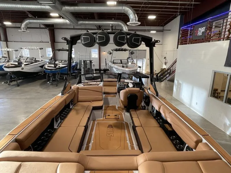Slide: The Image of 2025 Axis A245 boat interior with tan seating in a showroom. - 11