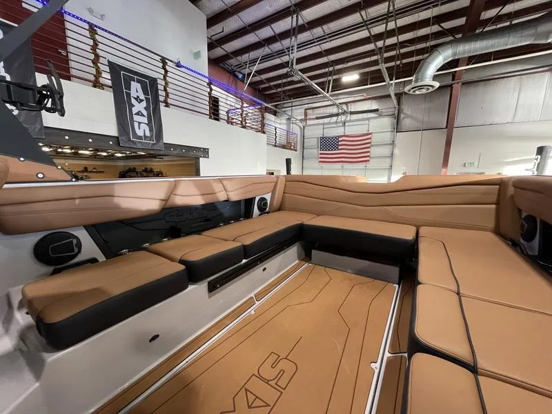 Slide: The Image of 2025 Axis A245 boat interior with tan seating in a showroom. - 14