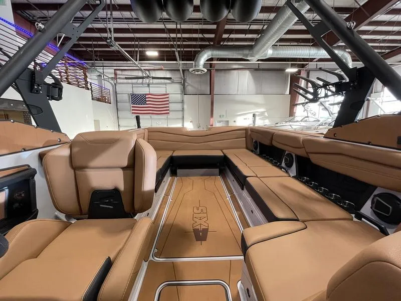 Slide: The Image of 2025 Axis A245 boat interior with tan leather seating in a showroom. - 20