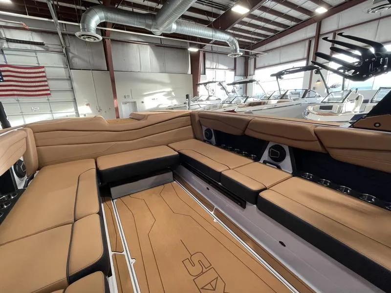 Slide: The Image of 2025 Axis A245 boat interior with tan seating in a showroom. - 21