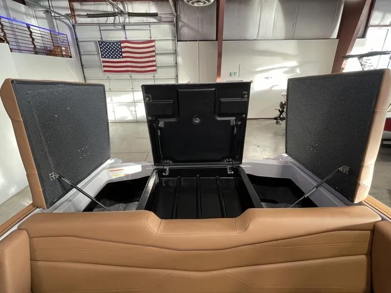 Slide: The Image of 2025 Axis A245 boat storage compartments open in a warehouse with American flag. - 25