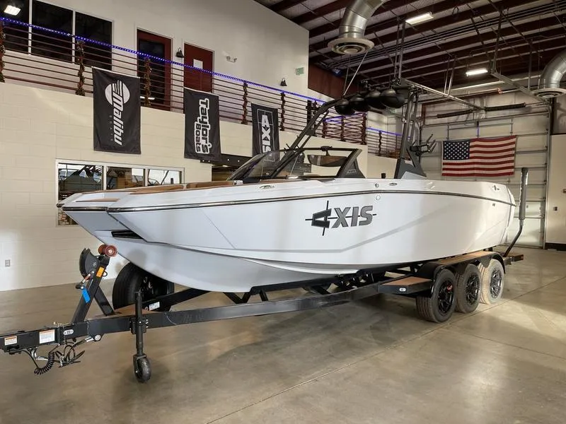 Slide: The Image of 2025 Axis A245 boat on trailer in showroom with American flag. - 3