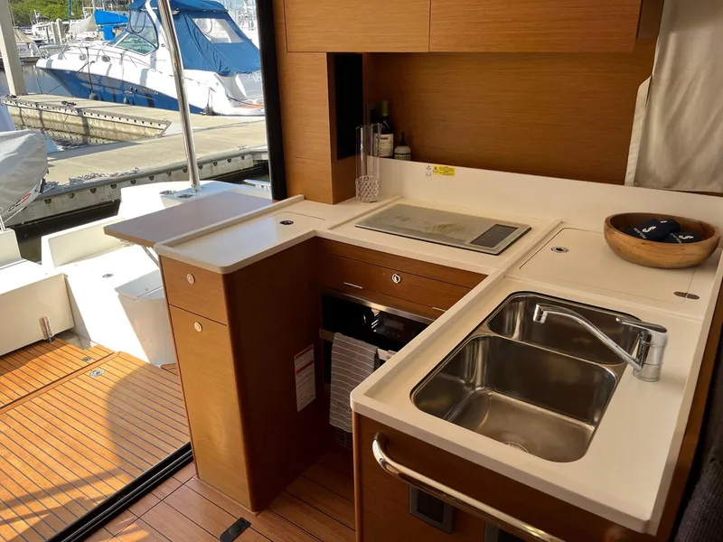 Slide: The Image of 2021 Beneteau Swift Trawler 41 kitchen with modern sink and stove, dock view. - 10