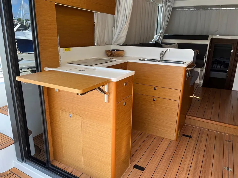 Slide: The Image of 2021 Beneteau Swift Trawler 41 interior kitchen with wood finish and modern amenities. - 11