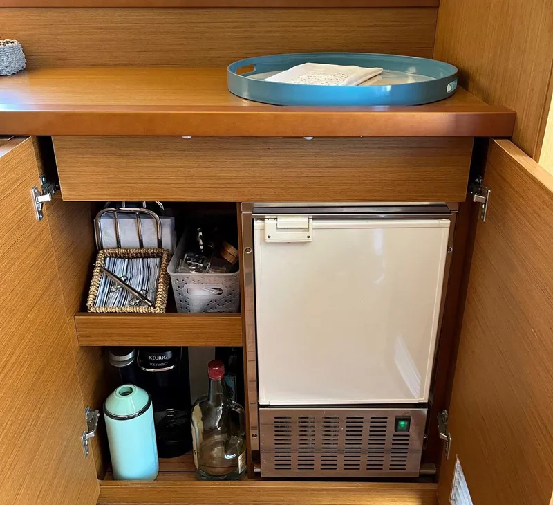 Slide: The Image of Beneteau Swift Trawler 41 interior cabinet with mini fridge and storage shelves, 2021 model. - 15