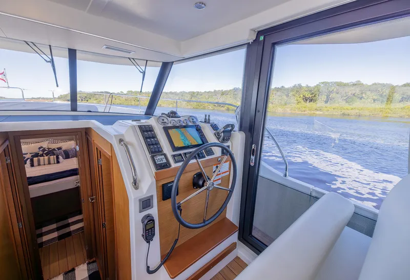 Slide: The Image of Interior view of 2021 Beneteau Swift Trawler 41 helm with navigation equipment. - 16