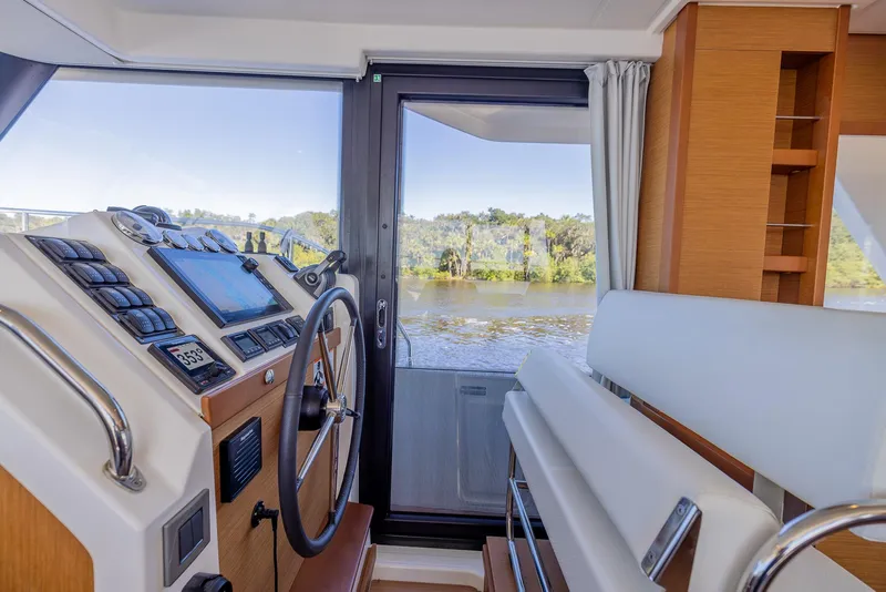 Slide: The Image of Interior helm of 2021 Beneteau Swift Trawler 41 with river view. - 17