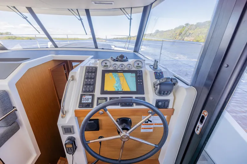 Slide: The Image of 2021 Beneteau Swift Trawler 41 helm with navigation system and steering wheel. - 18