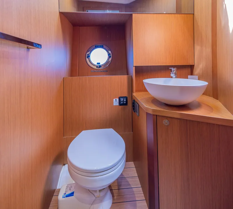 Slide: The Image of 2021 Beneteau Swift Trawler 41 bathroom with modern sink and wooden cabinetry. - 24