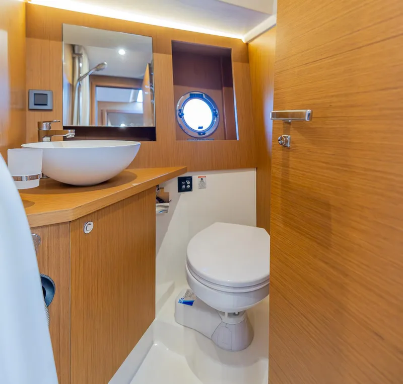 Slide: The Image of Modern bathroom in 2021 Beneteau Swift Trawler 41 with wood finish and round porthole. - 25