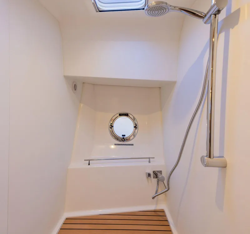 Slide: The Image of Shower area in 2021 Beneteau Swift Trawler 41 with wooden floor and porthole window. - 26