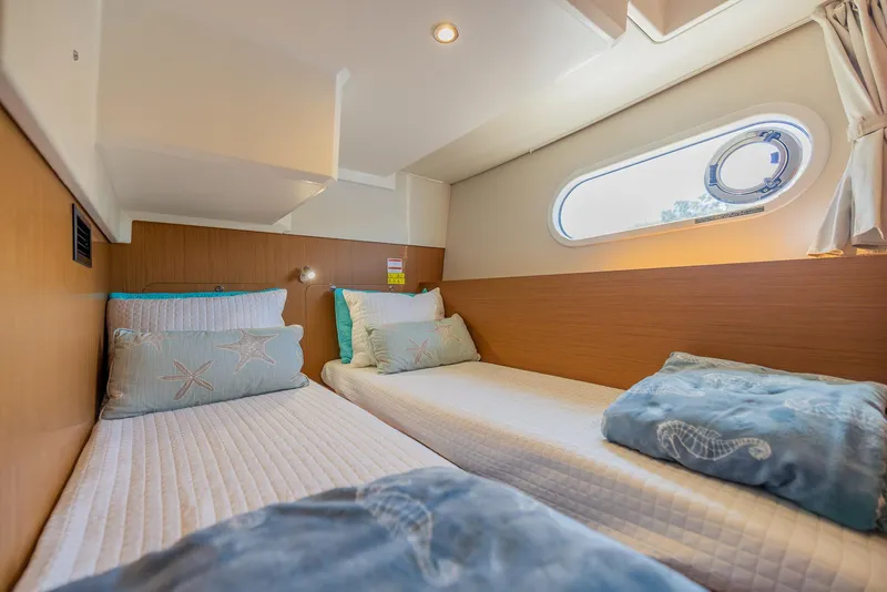 Slide: The Image of Cozy twin cabin in 2021 Beneteau Swift Trawler 41 with nautical-themed bedding. - 27