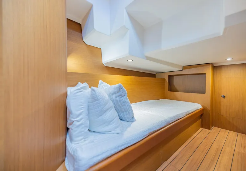 Slide: The Image of Cozy cabin interior of 2021 Beneteau Swift Trawler 41 with wooden finish and bedding. - 29