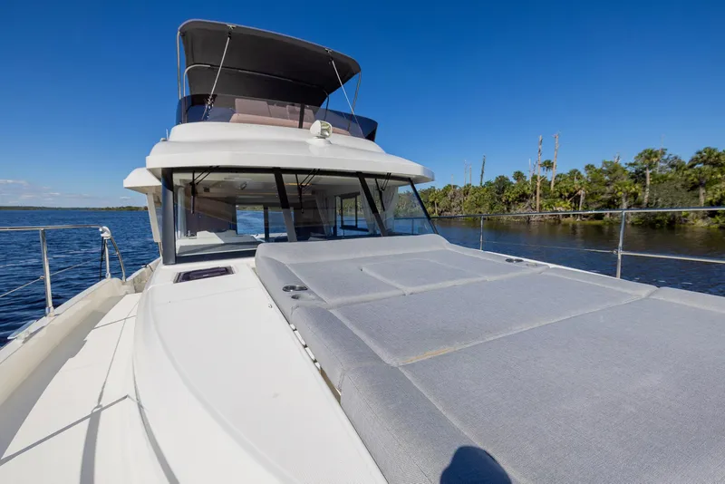 Slide: The Image of 2021 Beneteau Swift Trawler 41 on calm water, featuring spacious deck and modern design. - 35