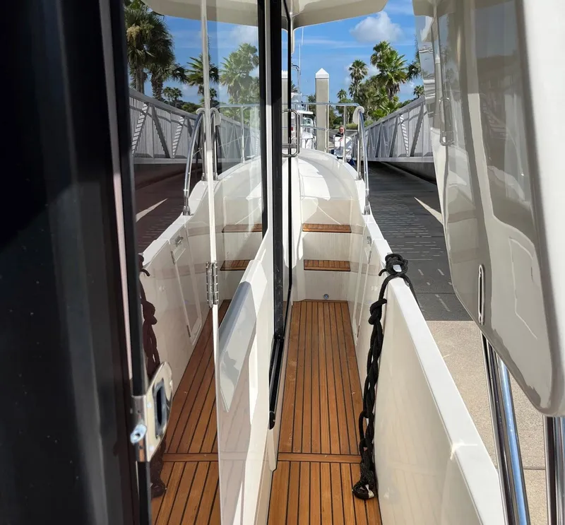 Slide: The Image of 2021 Beneteau Swift Trawler 41 with teak deck, docked near palm trees. - 38