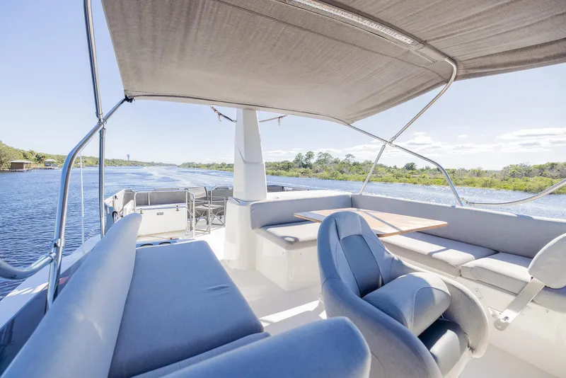 Slide: The Image of Beneteau Swift Trawler 41, 2021 model, featuring spacious outdoor seating and scenic water views. - 49