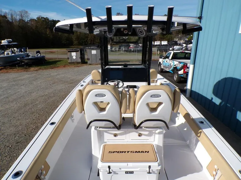 Slide: The Image of 2025 Sportsman Masters 267 boat interior with seating and console, parked outdoors. - 11