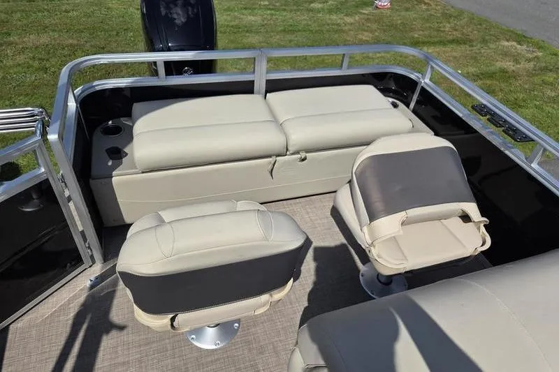 Slide: The Image of 2025 Sun Tracker SF 22 DLX pontoon boat interior with beige seating and cup holders. - 11
