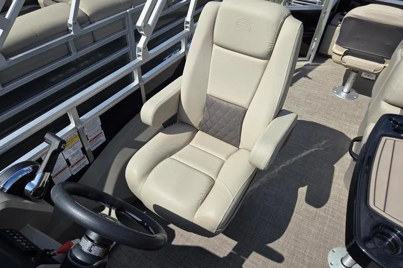 Slide: The Image of 2025 Sun Tracker SF 22 DLX boat interior with beige captain's chair and steering wheel. - 13