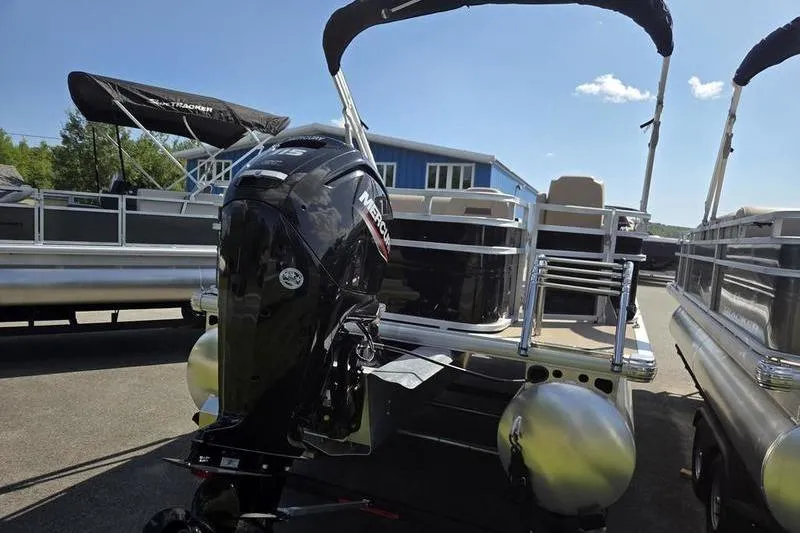 Slide: The Image of 2025 Sun Tracker SF 22 DLX pontoon boat with Mercury outboard motor, docked outdoors. - 4