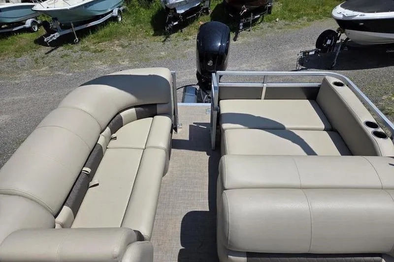 Slide: The Image of 2025 Sun Tracker PB 22 RF pontoon boat interior with beige seating and motor. - 15