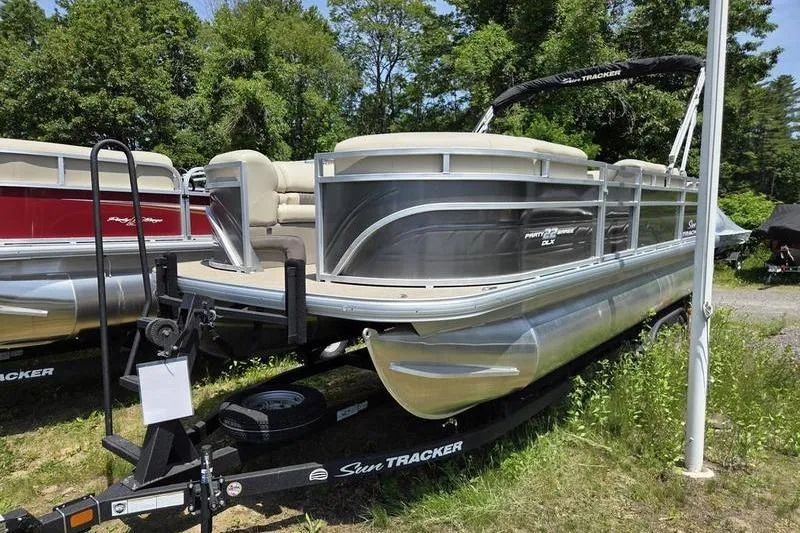 Slide: The Image of 2025 Sun Tracker PB 22 RF pontoon boat on trailer, parked outdoors. - 4