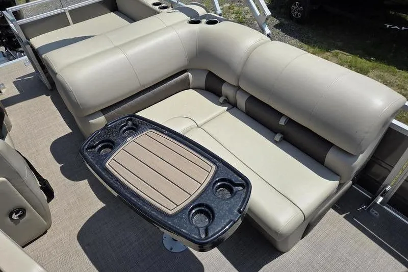Slide: The Image of 2025 Sun Tracker PB 22 RF boat interior with beige seating and a black table. - 6