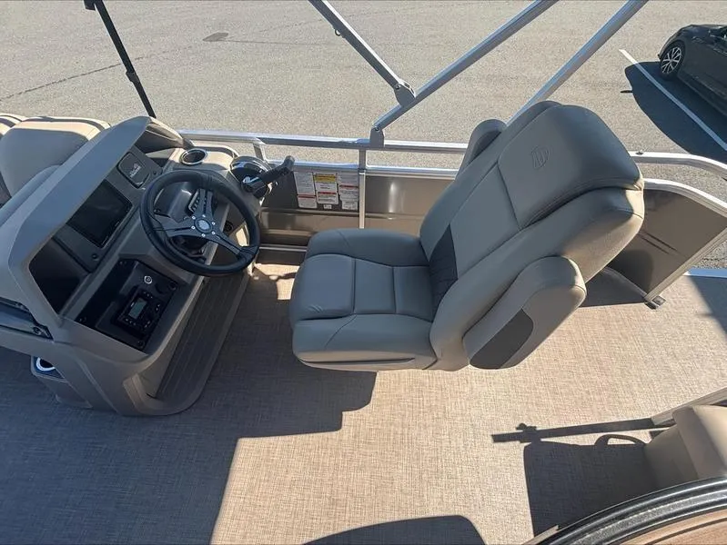Slide: The Image of 2024 Sun Tracker PB 20 DLX boat interior with steering wheel and captain's chair. - 2