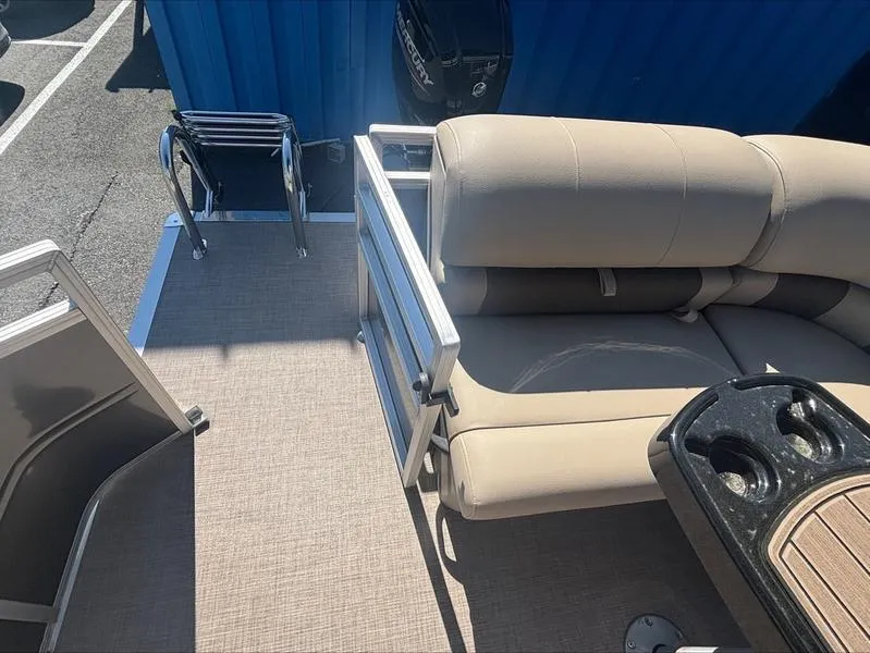 Slide: The Image of 2024 Sun Tracker PB 20 DLX pontoon boat interior with beige seating and cup holders. - 3