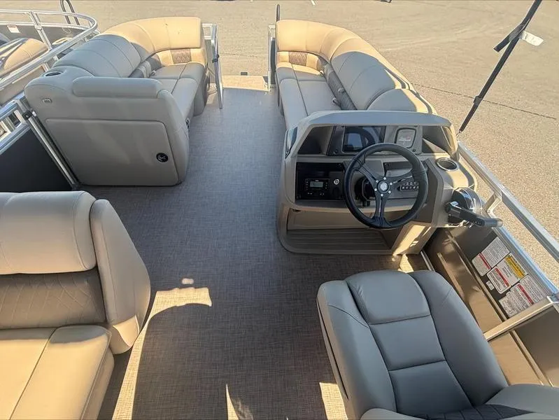 Slide: The Image of 2024 Sun Tracker PB 20 DLX pontoon boat interior with beige seating and steering console. - 7