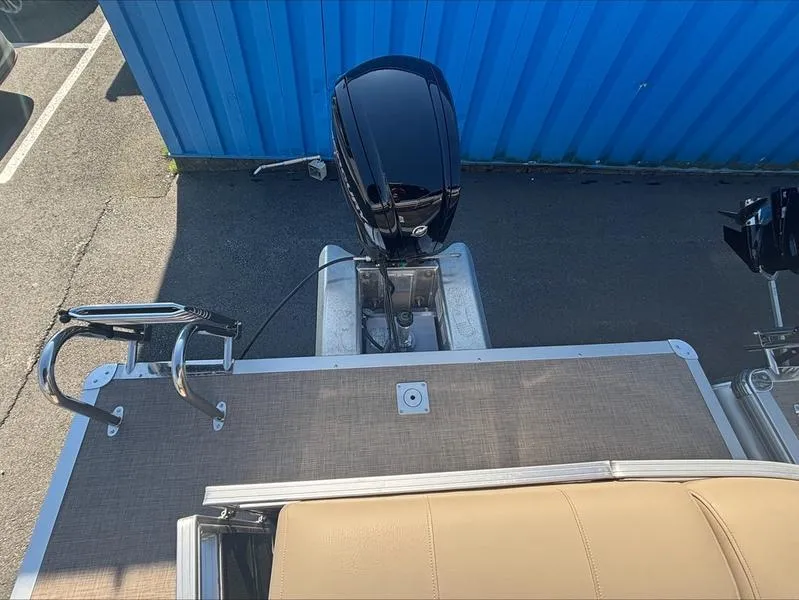 Slide: The Image of 2024 Sun Tracker PB 20 DLX pontoon boat with outboard motor, docked near blue wall. - 8