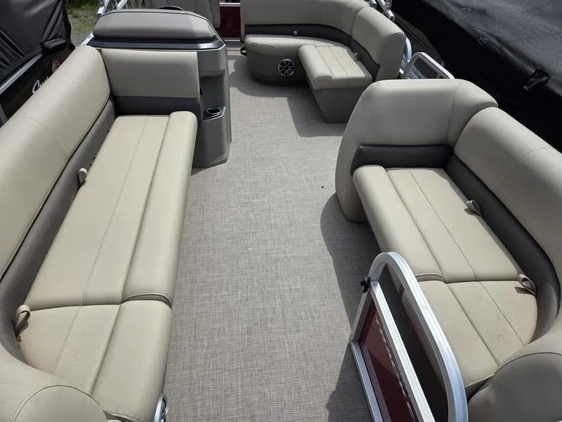 Slide: The Image of 2025 Sun Tracker PB 18 DLX pontoon boat interior with beige seating and spacious layout. - 10