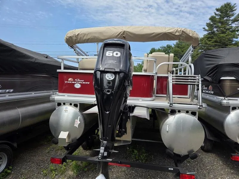 Slide: The Image of 2025 Sun Tracker PB 18 DLX pontoon boat with Mercury 60 HP engine, parked outdoors. - 6