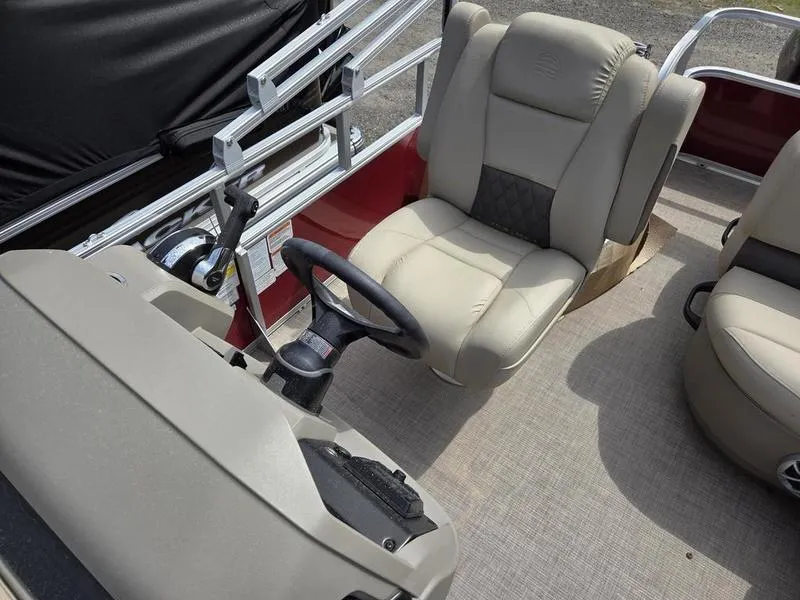 Slide: The Image of 2025 Sun Tracker PB 18 DLX boat interior with beige seating and steering wheel. - 8