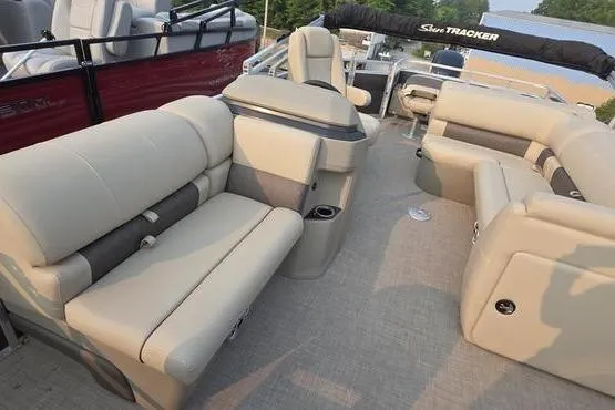 Slide: The Image of 2025 Sun Tracker FB 22 DLX pontoon boat with beige seating and spacious layout. - 11