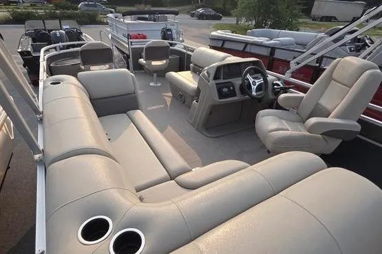 Slide: The Image of 2025 Sun Tracker FB 22 DLX pontoon boat interior with plush seating and modern dashboard. - 16