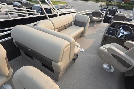 Slide: The Image of 2025 Sun Tracker FB 22 DLX pontoon boat interior with beige seating and steering console. - 7