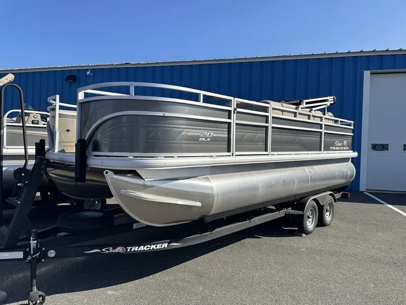 The Image of 2025 Sun Tracker FB 20 DLX pontoon boat on trailer, parked outdoors. - 0