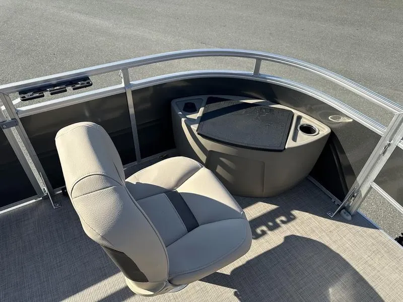 Slide: The Image of Sun Tracker FB 20 DLX 2025 boat interior with beige seating and storage area. - 11