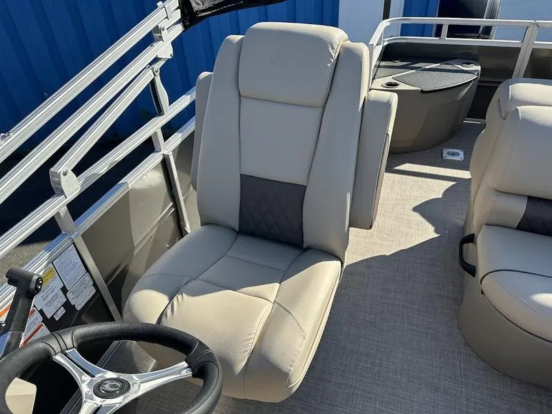 Slide: The Image of 2025 Sun Tracker FB 20 DLX boat interior with beige seating and steering wheel. - 8