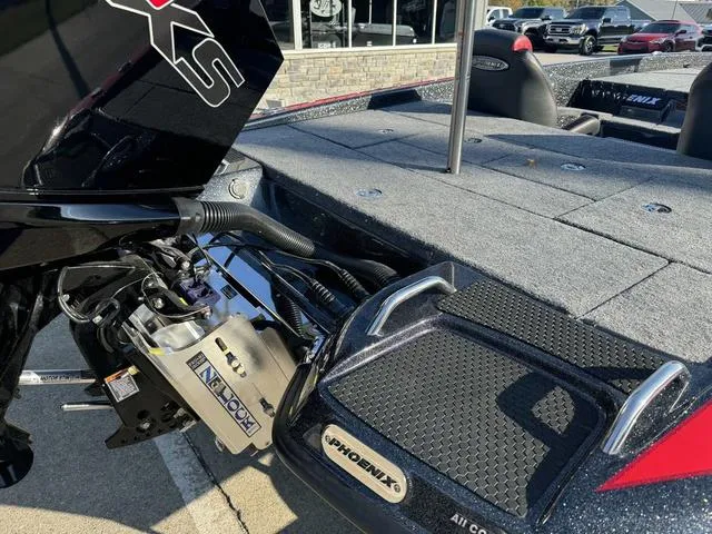 Slide: The Image of Phoenix 819 ZXL 2025 boat with motor and deck, parked outdoors. - 4